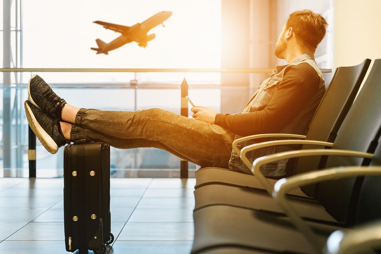 Viajera consulta en el móvil el estado de su vuelo dentro del aeropuerto