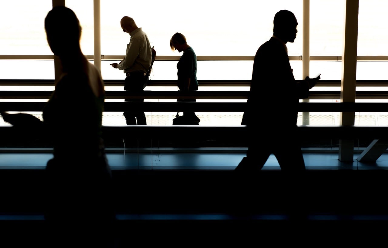 Pasajera consultando en el móvil cambios de vuelo dentro del aeropuerto