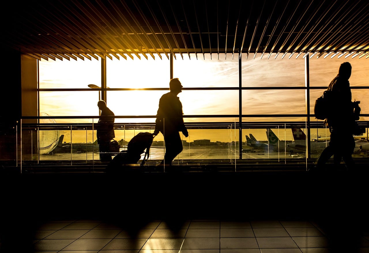 Viajera consulta en el móvil la información de su vuelo con documentos en la mano
