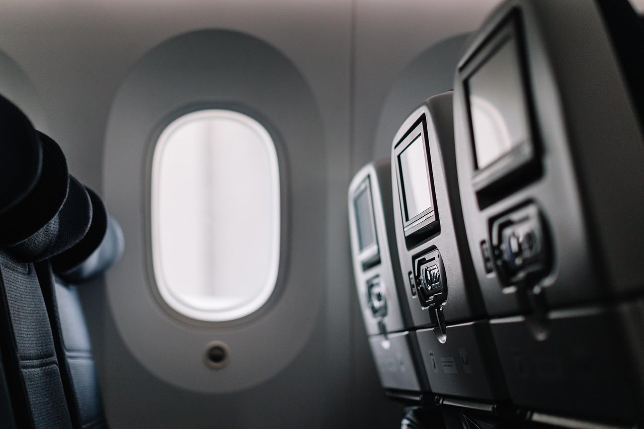 Viajera consultando en el móvil cambios de vuelo dentro de una terminal